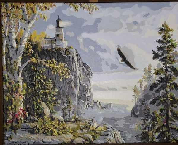 Guiding Light paint by numbers completed by a 2021 prize winner: a clifftop lighthouse with an eagle over the water