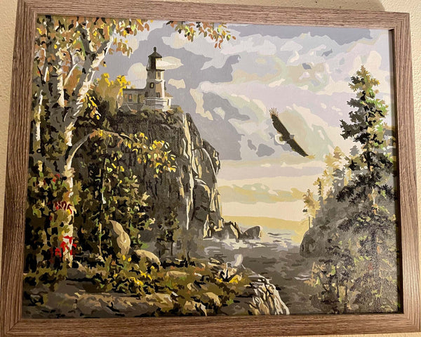 Guiding Light paint by numbers completed by Vicki C: a clifftop lighthouse with an eagle over the water