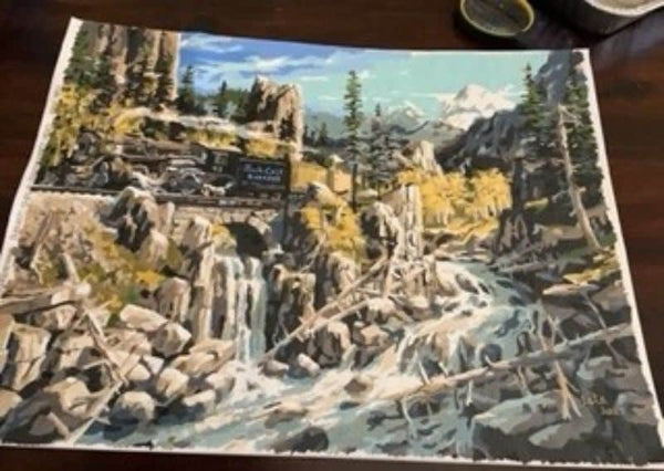 Paint by numbers completed by Pam C: a steam train crossing a stone bridge above a rocky gorge