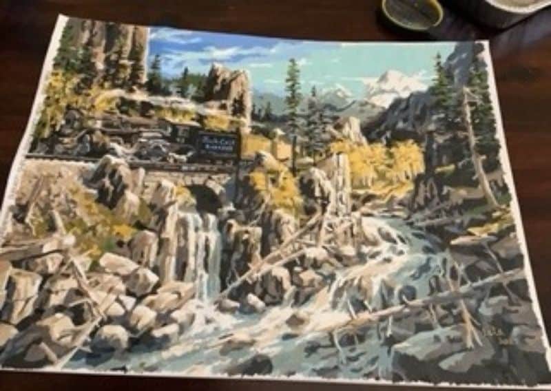 Paint by numbers completed by Pam C: a steam train crossing a stone bridge above a rocky gorge