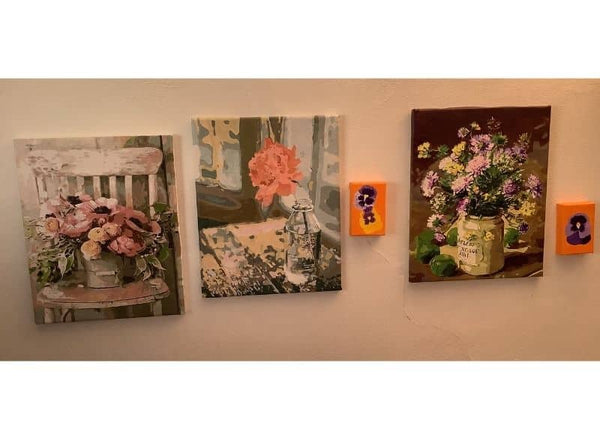 Paint by numbers completed by Sally: three framed flower paintings hung together on a wall