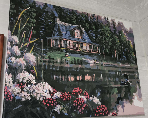 Still Waters paint by numbers completed by Justina R: a lit log cabin and a loon on a still northern lake