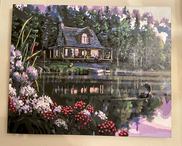 Still Waters paint by numbers completed by Vicki C: a lit log cabin and a loon on a still northern lake