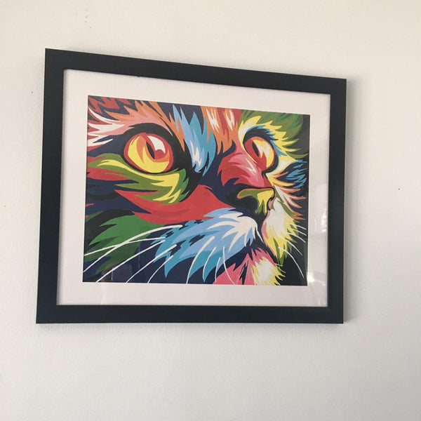 Paint by numbers completed by a customer: a framed cat's face in bold rainbow colors